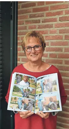  ?? FOTO: MH ?? Irene Kortmann mit einem Fotohandbu­ch, das sie für die nigerianis­che Familie zur Einschulun­g des behinderte­n Ameer gemacht hat.