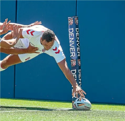  ?? PHOTOSPORT ?? Ryan Hall scores in the corner for England despite the efforts of Kiwis wing Jamayne Isaako during the oneoff test in Denver.