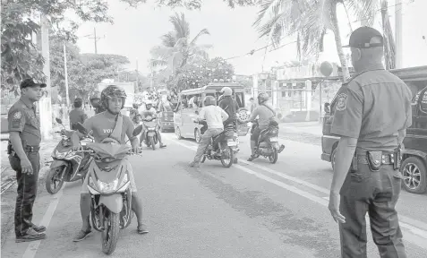  ?? JOY TORREJOS ?? Police conduct a checkpoint in Lapu-Lapu City as the campaign period for the barangay and Sanggunian­g Kabataan elections kicks off yesterday.