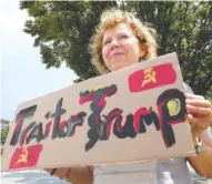  ?? STAFF PHOTO BY TIM BARBER ?? In front of the Chattanoog­a public library Tuesday, Judith Pedersen-Ben displays her hand-painted sign voicing her opinion on President Donald Trump’s comments Monday with Russian President Vladimir Putin.