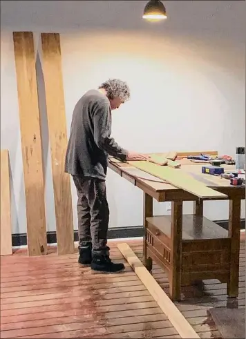  ?? Courtesy of Mahmood Karimi-hakak ?? Mahmood Karimi-hakak measures wood at Cafe Dialogue in Schenectad­y. The Siena College professor chose to do many of the renovation­s to the former Copper Keg building by himself.