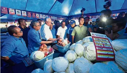  ?? — Bernama ?? Fresh greens: Najib inspecting the vegetables sold at the Jimat Belanja Dapur programme at Padang Awam Bandar Dara Chini in Pekan.