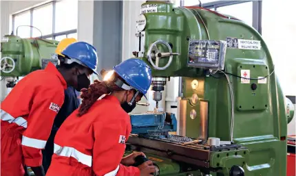  ?? ?? Engineers operate a milling machine at the UIRI in Kampala, Uganda