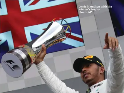  ??  ?? Lewis Hamilton with the winner’s trophy Photo: AP