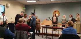  ?? DAN SOKIL - MEDIANEWS GROUP ?? New Upper Gwynedd police Officer Montana Lighthart, center, receives his badge and oath before family and friends during the township commission­ers’ meeting on Monday.