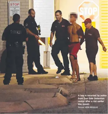  ?? Picture: KERI MEGELUS ?? A boy is escorted by police from Don Dale Detention centre after a riot earlier this month