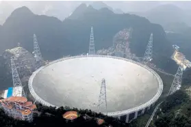  ?? Chinatopix via The Associated Press ?? The Five-Hundred-Meter Aperture Spherical Telescope in southwest China's Guizhou province is the world's largest radio telescope. Its search for signals from stars and galaxies demonstrat­es China’s rising ambitions in space and its pursuit of internatio­nal scientific prestige.