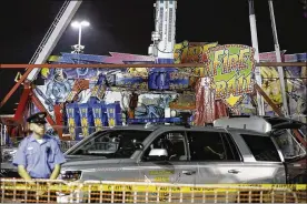  ?? BARBARA J. PERENIC / THE COLUMBUS DISPATCH ?? Authoritie­s stand near the Fire Ball amusement ride after the ride malfunctio­ned, killing one person and injuring several others at the Ohio State Fair last month in Columbus. Some of the victims were thrown from the ride when it malfunctio­ned, said...