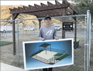  ?? Courtesy photo ?? Zach Fineberg holds up the plans for his completed Eagle Scout Project at the Castaic Animal Care Center earlier this month. The 16-year-old Saugus High junior said the center loved the idea.