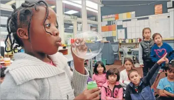  ?? Photos: NICHOLAS
BOYACK ?? Gloria Mugiraneza, 7, uses bubbles to demonstrat­e to her classmates how far germs can travel from a sneeze.