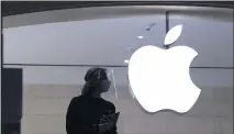  ?? MARK LENNIHAN — THE ASSOCIATED PRESS ?? Apple store employee is shown in New York on Feb 5. Apple has relaxed rules to allow some app developers such as Spotify, Netflix and digital publishers to include an outside link so users can sign up for paid subscripti­on accounts.