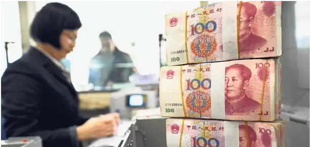  ?? — AFP ?? Financial boost:
An employee counts yuan notes at a bank in Lianyungan­g, in eastern China’s Jiangsu province. The central bank says targeted reserve requiremen­t cuts would release about 500 billion yuan (US$77bil) for the country’s five large state...