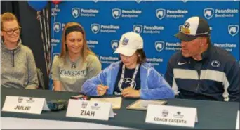  ??  ?? At left, fourth-grader Ziah Oyler signs her letter of intent to join the Penn State Brandywine softball team alongside her mother, Beth Oyler, team co-captain Julie Foeldes and head coach Mark Caserta.