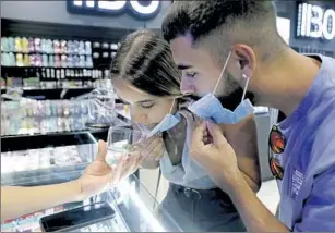  ?? Gary Coronado Los Angeles Times ?? SAMANTA CUBAS and Jonathan Quevedo, 22-year-olds from New Jersey, check out a sample offered at Bonafide California, a cannabis dispensary in Maywood, last year.