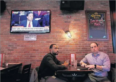  ?? [CAROLYN COLE/LOS ANGELES TIMES] ?? As they finish lunch Thursday at the Tonic bar and restaurant near New York’s Times Square, Chandler Green, left, of New Jersey, and Sam Henderson, of Norfolk, Virginia, watch one of the many screens showing former FBI Director James Comey’s testimony.