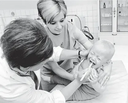  ?? FOTO ČTK ?? Očkování proti spalničkám u nás začalo v roce 1969. (Vyšetření před očkováním v dětském středisku v Sokolovské ulici v Praze.)