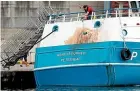  ?? AP ?? A crew member cleans marks from the stern of the Honeybourn­e 3, a Scottish scallop dredger, attacks by French fishing vessels.