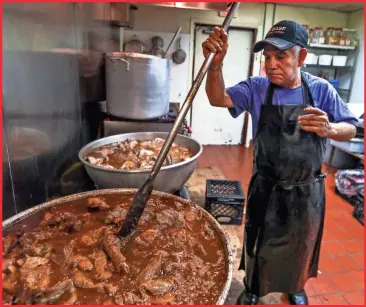  ?? EBONY COX / MILWAUKEE JOURNAL SENTINEL ?? Jose Luis Mejia stirs carnitas as they simmer in July at Carnitas Don Lucho in Milwaukee. About 1,500 pounds of carnitas are served over a three-day period. The 70-year-old Mejia is the restaurant's namesake; his nickname is Don Lucho.