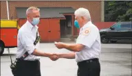  ?? Jeannette Ross / Hearst Connecticu­t Media ?? Deputy Chief Jim Blanchfiel­d, left, is congratula­ted on his promotion by Wilton Fire Department interim Chief Geoff Herald on July 1.