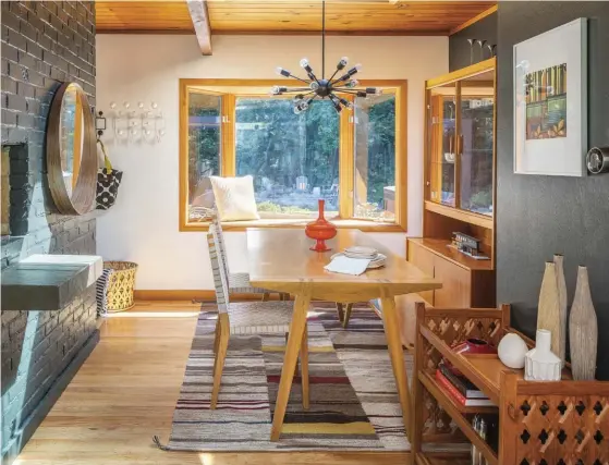  ??  ?? THE DINING AREA CONTAINS SUBTLE MIDCENTURY NODS, LIKE THE TABLE AND CHAIRS FEATURING SLEEK LINES AND LIGHT WOODS. A VINTAGE DANISH HUTCH, RENDERED IN TEAK, WAS DISCOVERED AT A THRIFT STORE AND FITTINGLY HOUSES UPCYCLED FINDS.