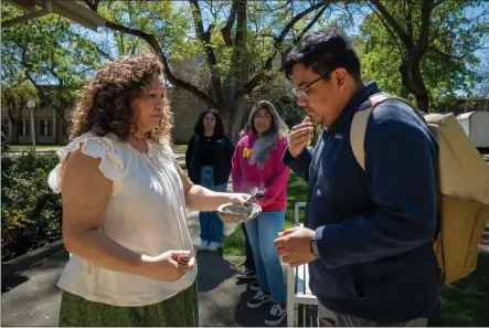  ?? PHOTO BY JOSÉ LUIS VILLEGAS FOR CALMATTERS ?? Carlos Morales and Michelle Villegas-Frazier participat­e in a sage burning ritual outside of the Native American Academic Student Success Center at UC Davis on April 1, 2024.