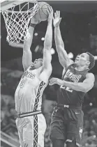  ?? DARREN ABATE/AP ?? San Antonio Spurs’ Keldon Johnson (3) dunks against Memphis Grizzlies’ Desmond Bane during the first half of an NBA basketball game on Friday in San Antonio.