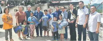  ??  ?? Jamit (fourth left) poses with the children after presenting them with school bags.