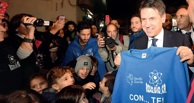  ??  ?? Forcella In alto il premier Conte durante la sua visita a Napoli accolto dai bimbi di Forcella; in basso Salvini e Di Maio