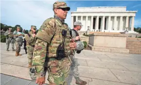  ?? MANUEL BALCE CENETA/AP ?? Members of the National Guard walk to their designated positions at the National Mall near the Lincoln Memorial, in Washington on Wednesday.