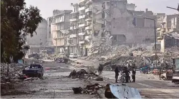  ??  ?? SEKUMPULAN askar Syria berdiri berhampira­n bangunan yang musnah di daerah Sukkari di bandar Aleppo
yang dulunya antara kubu kuat pejuang penentang kerajaan Presiden
Bashar al-Assad. - AFP