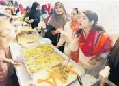  ?? STEPHEN M. DOWELL/STAFF PHOTOGRAPH­ER ?? Muslim women serve food Wednesday in the women’s area outside Jama Masjid of Orlando mosque.