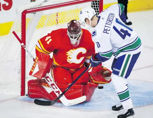  ?? — THE CANADIAN PRESS ?? Vancouver Canucks’ Elias Pettersson tries to get the puck past Flames goalie Mike Smith.