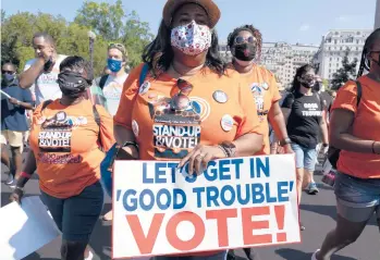  ?? JOSE LUIS MAGANA/AP ?? Fighting for voting rights: Demonstrat­ors hold signs Saturday during a march for voting rights, marking the 58th anniversar­y of the March on Washington in Washington, D.C. Hundreds of thousands of voting rights advocates rallied across the country Saturday to call for sweeping protection­s against a further erosion of the Voting Rights Act of 1965.