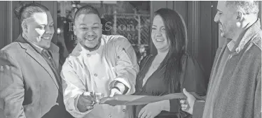  ?? RICK CINCLAIR/TELEGRAM & GAZETTE ?? Chef Darien Moronta, center, cuts the ceremonial ribbon with Blackstone Herbs & Martini Bar owners Gian and Bryanna Ranucci on Feb. 1, 2023. City Manager Eric D. Batista, right, attended the Green St. opening along with other city officials.