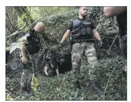  ?? (Photo AFP) ?? Les gendarmes fouillent les moindres recoins de la zone boisée jouxtant la salle des fêtes.