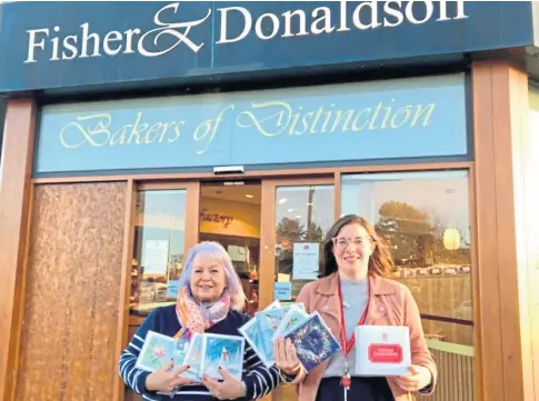  ?? ?? FUNDRAISIN­G: TCCL’s Gaye Steel with Chloe Milne and a sample of Christmas cards at Fisher & Donaldson.