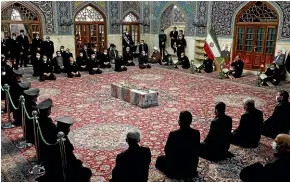  ?? AP ?? People pray over the flag-draped coffin of Mohsen Fakhrizade­h, an Iranian scientist linked to the country’s disbanded military nuclear programme who was killed on Saturday.