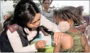  ??  ?? PREVENTION: A child gets immunised by a nurse.