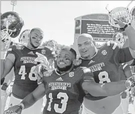  ?? Ji m Lytle Associated Press ?? RYAN BROWN ( 48), Josh Robinson ( 13) and Nick James celebrate Mississipp­i State’s 48- 31 win over No. 6 Texas A& M. Mississipp­i took down No. 3 Alabama.