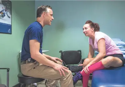  ?? CHARLIE LEIGHT/THE REPUBLIC ?? Amy Van Dyken-Rouen reviews the session she just completed with Al Biemond, a physical therapist at Barrow Neurologic­al Institute in Phoenix. She must constantly battle through what she calls “mother of pearl” pain in rehab as well as in strength and...