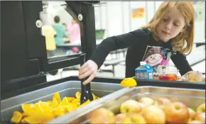  ?? BEA AHBECK/NEWS-SENTINEL ?? First grader Izzy Rubio, 7, takes orange slices from the salad bar at Valley Oaks Elementary School in Galt on Friday.