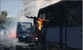  ?? YORGOS KARAHALIS — THE ASSOCIATED PRESS ?? A protester tries to damage a police vehicle during scuffles in part of an anti-fascist rally outside the courthouse in Athens on Wednesday.