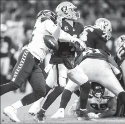  ?? BETTINA HANSEN/TRIBUNE NEWS SERVICE ?? Seattle Seahawks defensive end Frank Clark sacks Oakland Raiders quarterbac­k Derek Carr and strips the ball on Oct. 14 at Wembley Stadium in London.