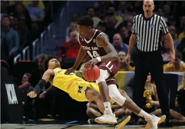  ?? Associated Press ?? ■ Texas A&M forward Robert Williams (44) drives against Michigan guard Jordan Poole during the first half of an NCAA men's college basketball tournament regional semifinal Thursday in Los Angeles.