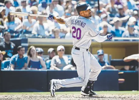  ?? Photos by Denis Poroy, Getty Images ?? Left fielder Ian Desmond produces his 700th career RBI with a single during the sixth inning Sunday at Petco Park that scored Ryan McMahon from second base, giving the Rockies a 3-2 lead over the San Diego Padres.