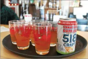 ?? LAUREN HALLIGAN — LHALLIGAN@DIGITALFIR­STMEDIA.COM ?? Craft beer like this Saratoga Sunrise wheat ale is served at a ribbon cutting event on Thursday for 518 Craft and The Shmaltz Shop.