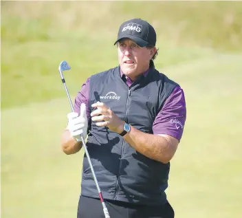  ?? GREGORY SHAMUS/GETTY IMAGES ?? Phil Mickelson, seen watching his approach shot during a practice round before the British Open at Royal Birkdale in Southport, England on Tuesday, says he’ll opt to use a three-wood instead of a driver given a lack of wind and the course’s tough links...