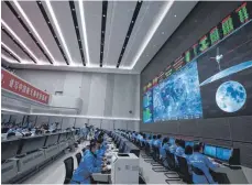  ?? FOTO: JIN LIWANG/DPA ?? Technische­s Personal überwacht den Transfer der auf dem Mond gesammelte­n Proben vom Aufstiegsm­odul zum Rückkehrer der chinesisch­en Sonde „Chang’e 5“im Beijing Aerospace Control Center.