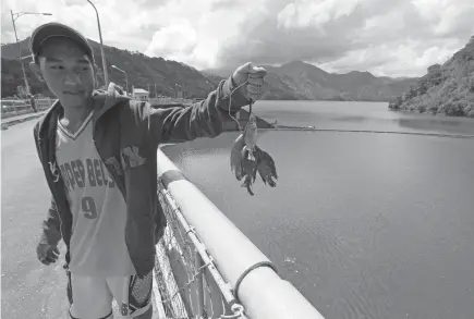  ?? Photo by JJ Landingin ?? GONE FISHING. A resident from Ambuklao benefits from the fishpen of the dam which has also been providing livelihood for the nearby locals.