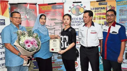  ??  ?? Useful assistance: Mastura (second from left) presenting Takaful and death coverage benefits to Bao Yi at Kluang PTPTN branch. Looking on are (from left) PTPTN senior general manager Abdul Ghaffar Yusop, Hong Leong MSIG Takaful general manager of...